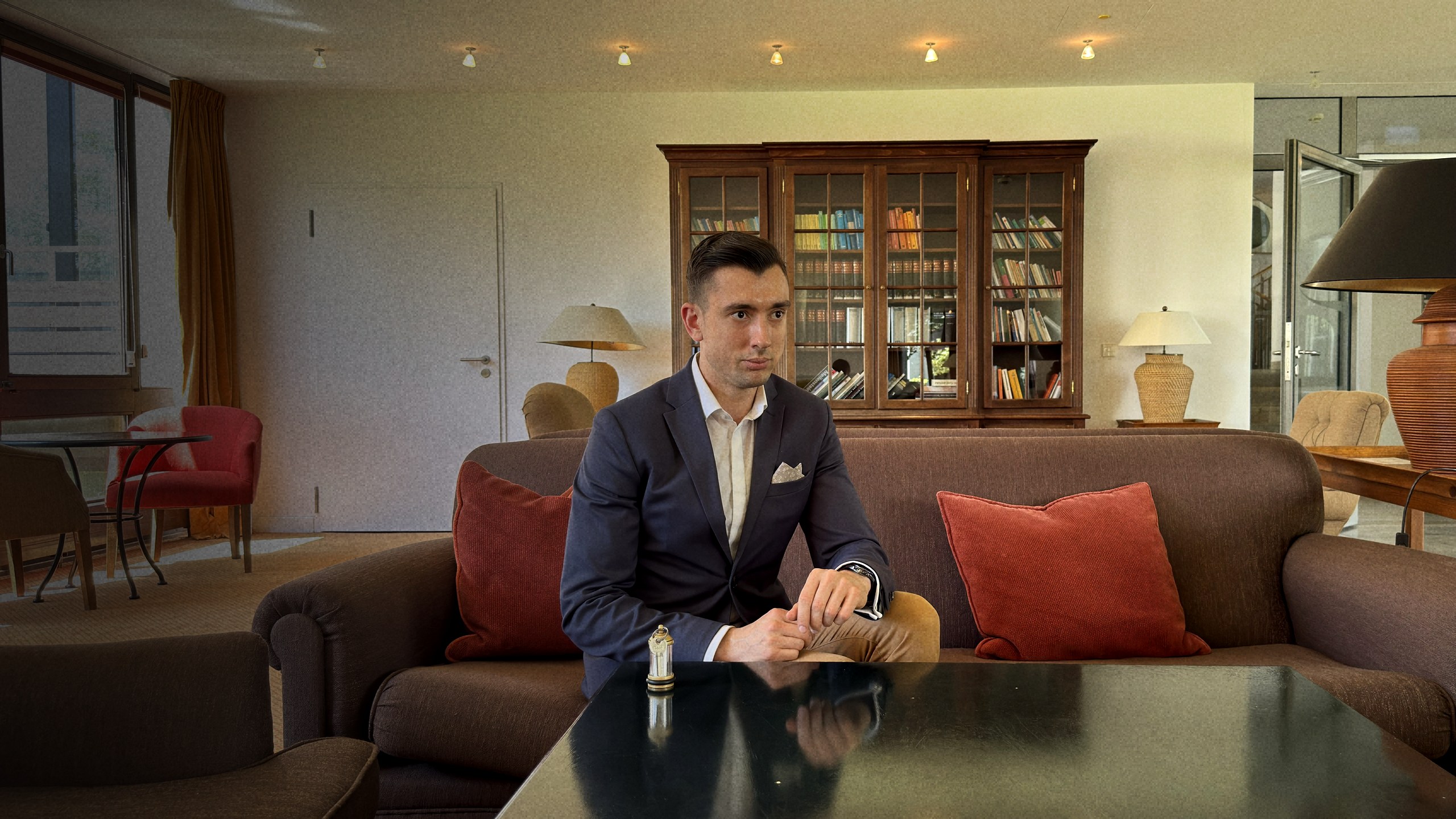 Miguel Miranda, Gründer des Miranda Institute, in einem stilvollen Raum mit Bücherregal im Hintergrund